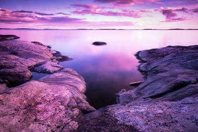 Pôr do sol sereno sobre um lago tranquilo com céu roxo e rosa