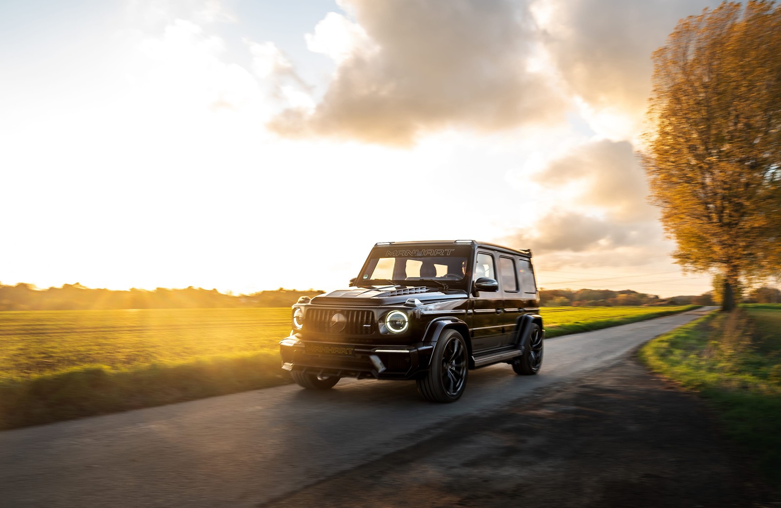 Arabisch schwarzer mercedes g-klasse fährt eine landstraße entlang (rad, gelb, mercedes benz g class, jeep, kompaktwagen)