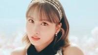 Momo von TWICE in einem ruhigen blauen Konzeptsetting, das ihren fesselnden Blick und eleganten Stil zeigt.