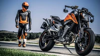 Motocicleta KTM com piloto em equipamento laranja na estrada aberta