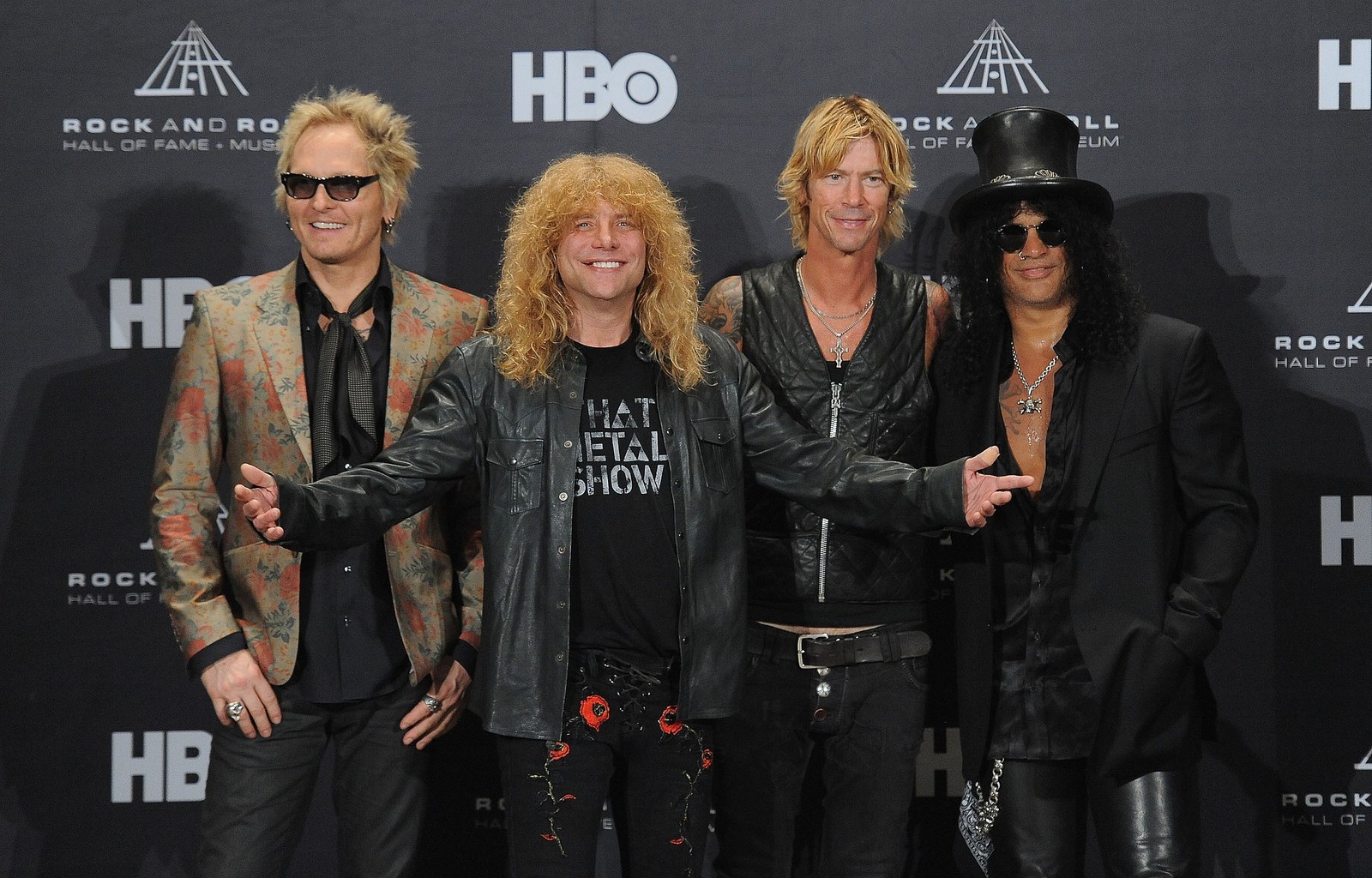 Un grupo borroso de miembros de una banda de rock posando para una foto (steven adler, guns n roses, roca, baterista, evento)