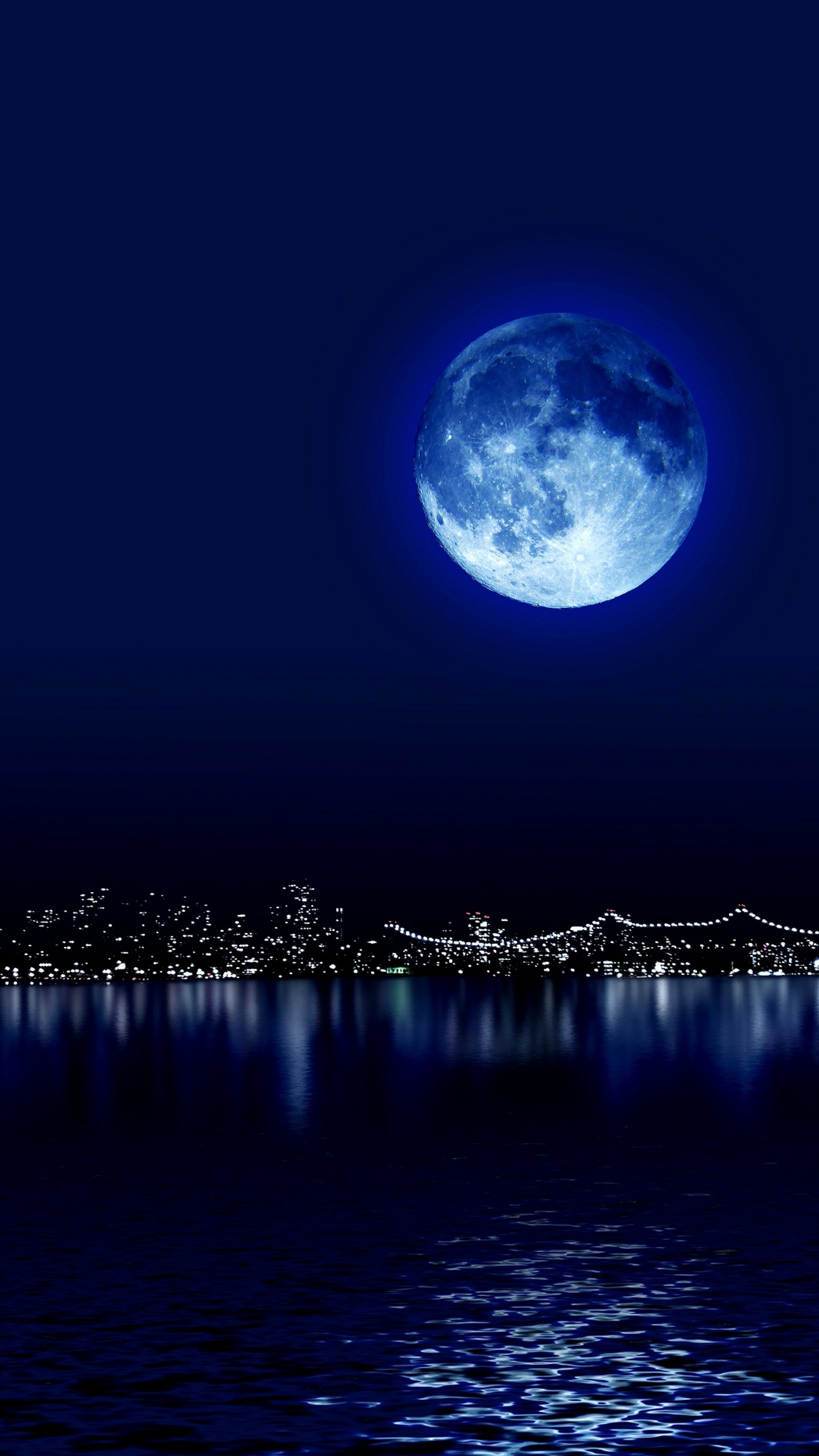 Un primer plano de una luna llena sobre una ciudad de noche (azul, ciudad, luna, noche, reflexión)