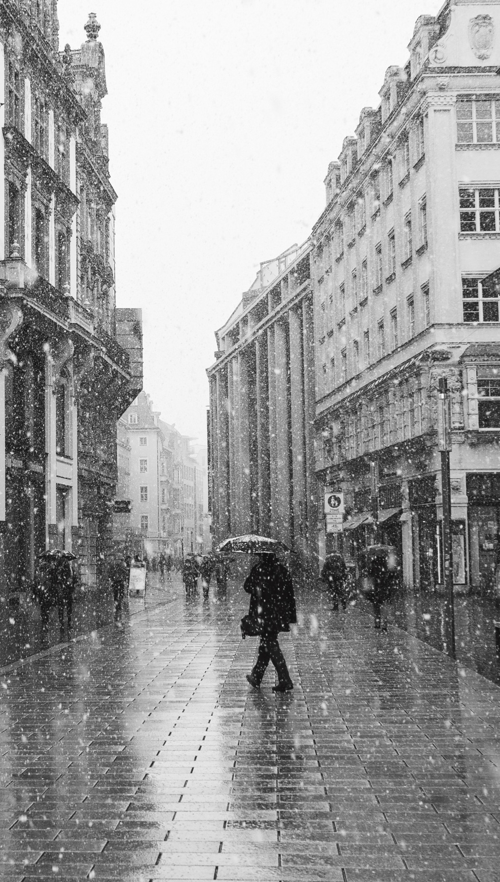 Il y a une personne marchant dans la rue dans la neige (ville, nature, enneigé, hiver)