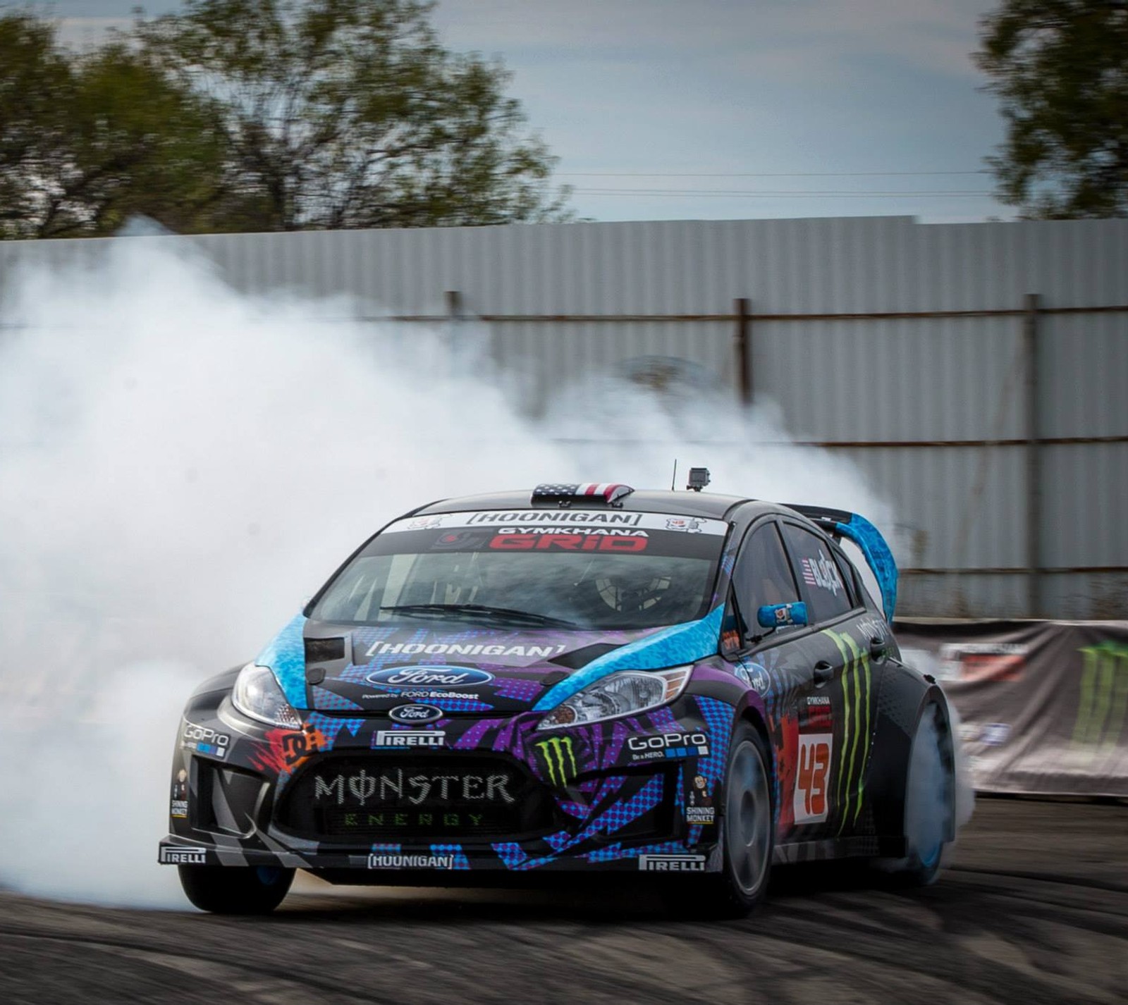 Coche árabe con pintura azul y morada conduciendo en una pista (drifting, ford, ken block)