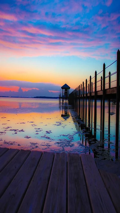 Gelassener Sonnenuntergang über einem ruhigen Dock und Reflexion auf ruhigem Wasser