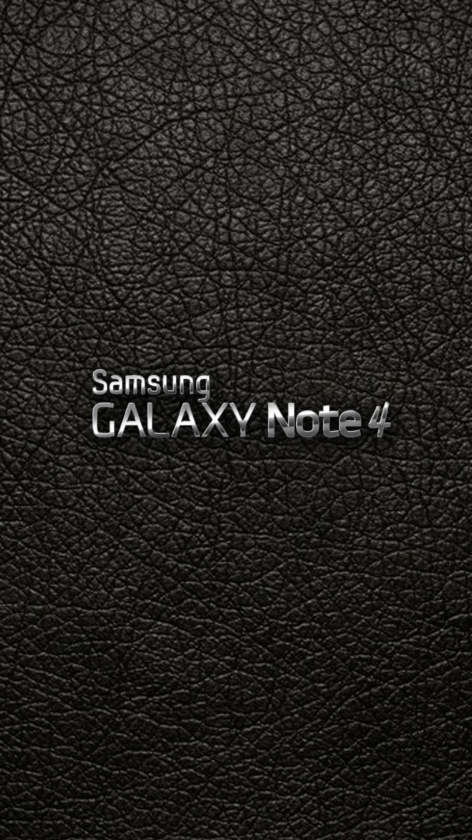 A close up of a black leather surface with a silver logo (galaxy note, galaxy note 4, note, samsung)