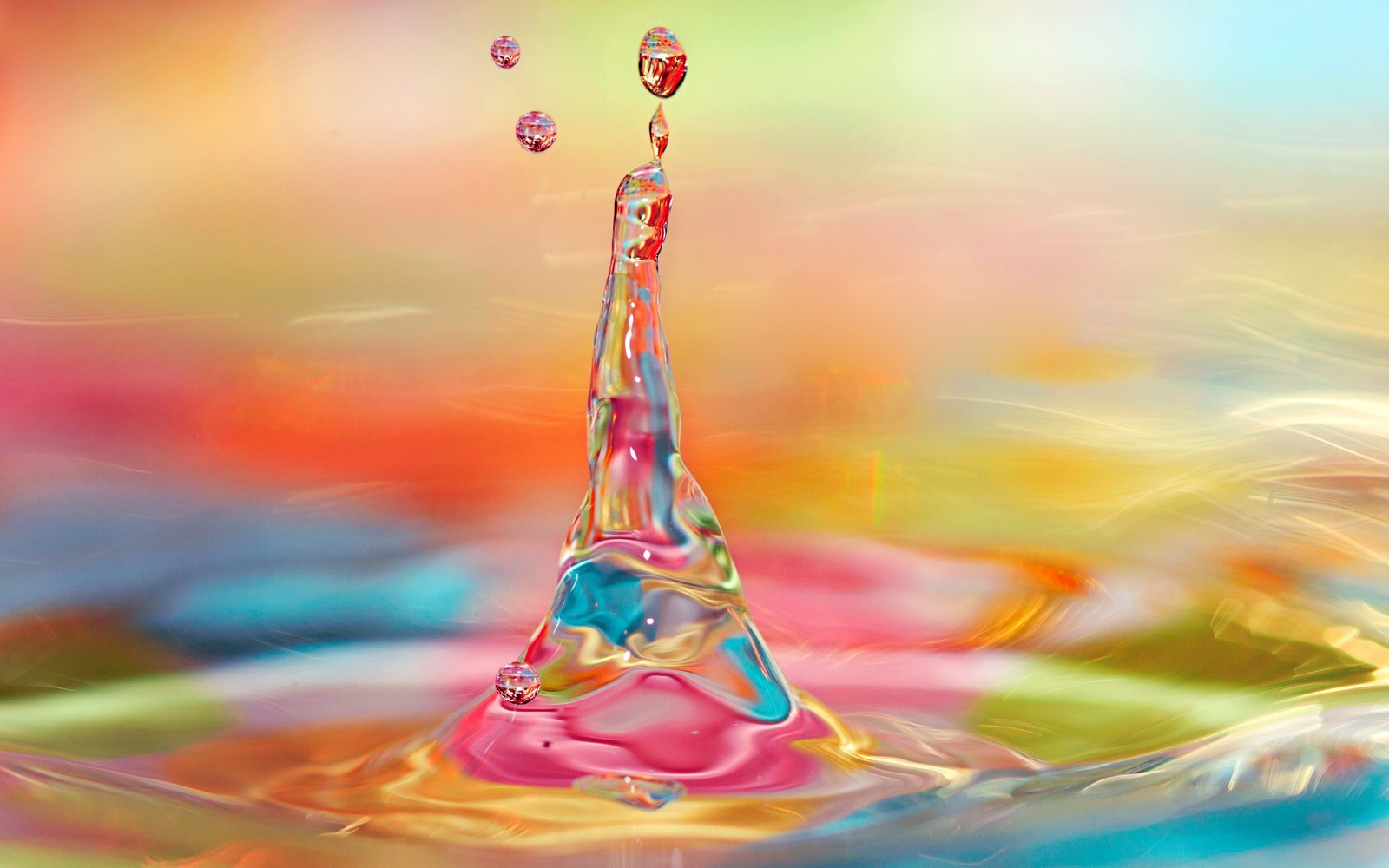 Un gros plan d'une goutte d'eau avec un fond coloré en arc-en-ciel (art, eau, goutte, liquide, bulle liquide)