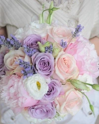 Elegante buquê de noiva em tons pastel com rosas de jardim, lavanda e peônias em tons de rosa e roxo.