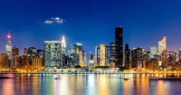 Beeindruckende Skyline von Manhattan bei Nacht mit Reflexionen im Wasser