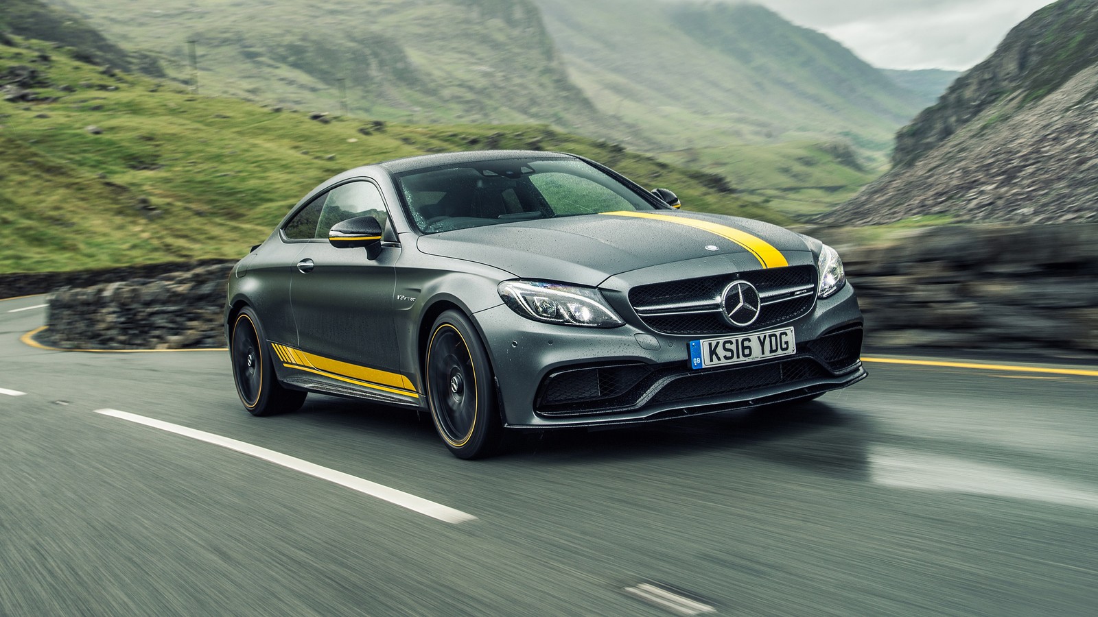 El mercedes c class coupe conduciendo por una carretera de montaña (coche, coche mediano, automóvil deportivo, coche de lujo, coche deportivo)