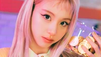 Chaeyoung de TWICE tenant un pot de pièces, dégageant un charme captivant sur un fond vibrant et coloré.