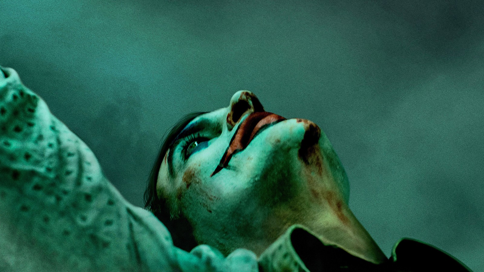 Verfremdetes bild einer frau mit blutigem gesicht und grünem mantel (joker 2019, film, joker, joaquin phoenix, juaquin phoenix)