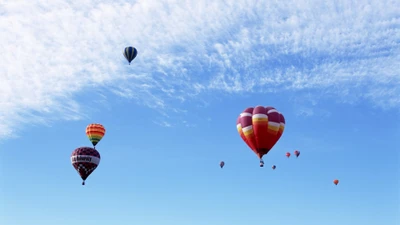 Balões de ar quente vibrantes pairando em um céu azul claro