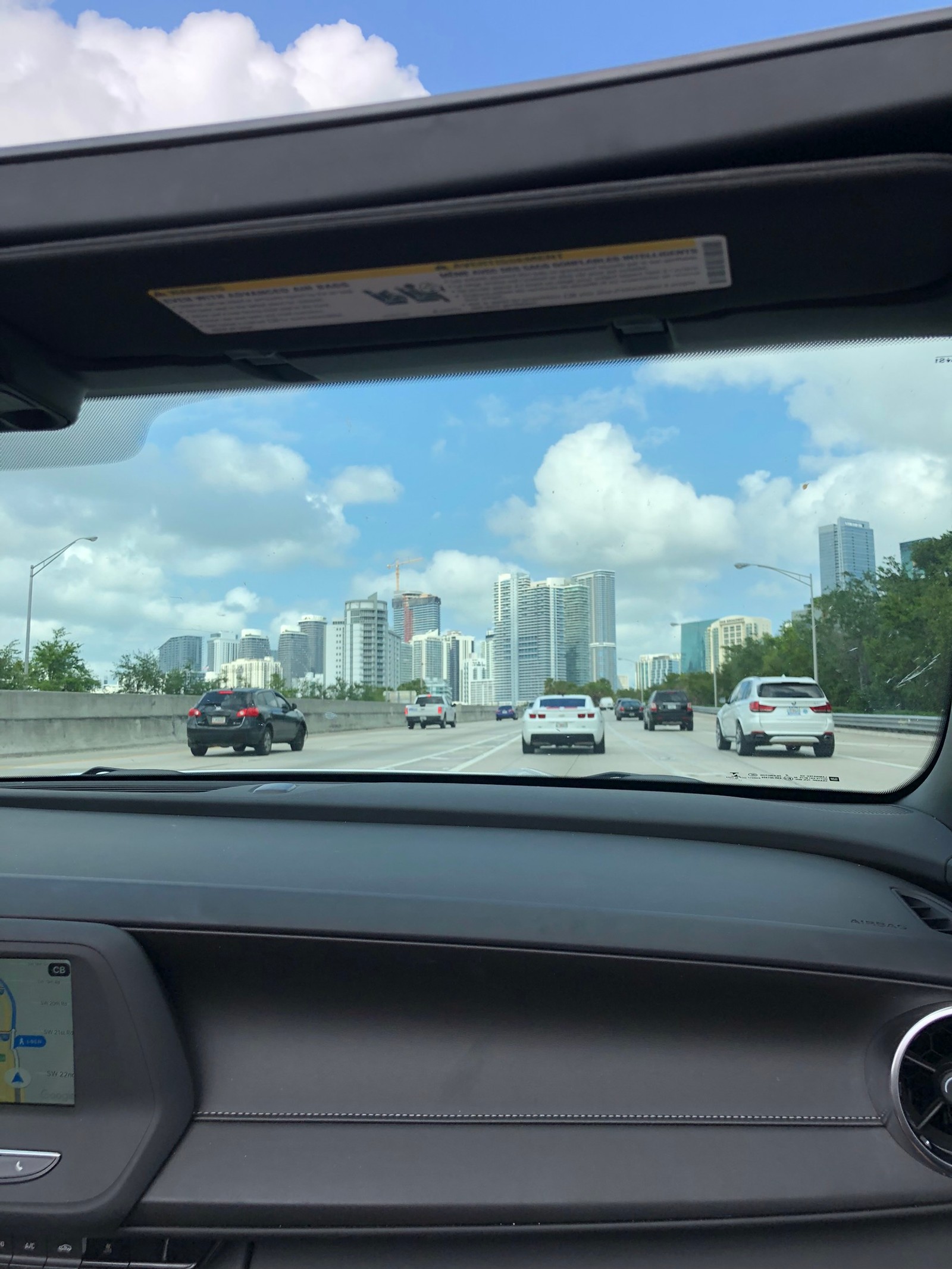 Panoramaansicht einer stadt aus dem autofenster mit blick auf die autobahn (familienauto, könig, kompaktwagen, mittelklassewagen, automobilspiegel)