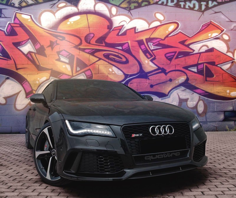 A close up of a car parked in front of a graffiti covered wall (beast, black)