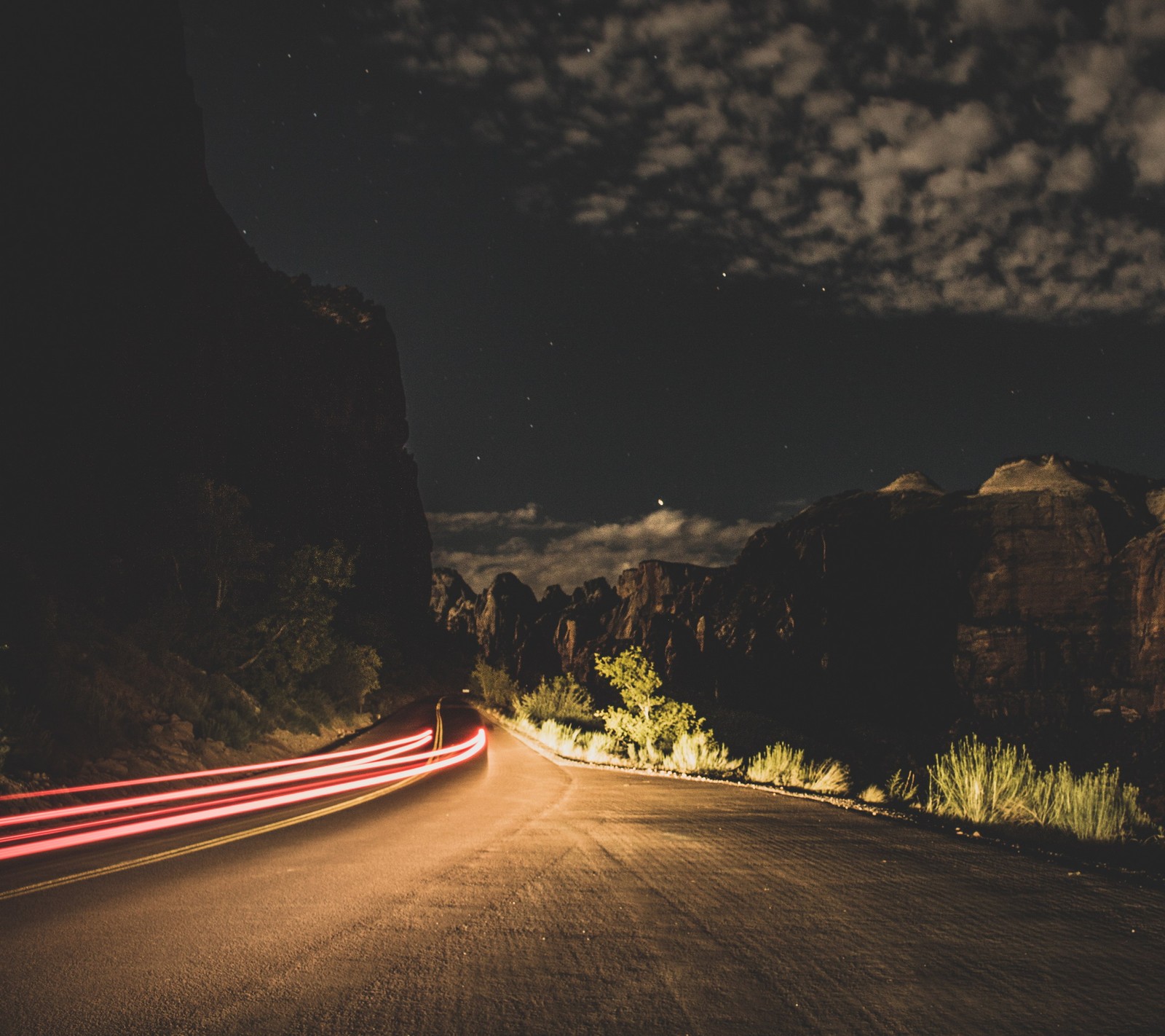 Uma vista editada de uma estrada com um carro passando à noite (noite, noche)