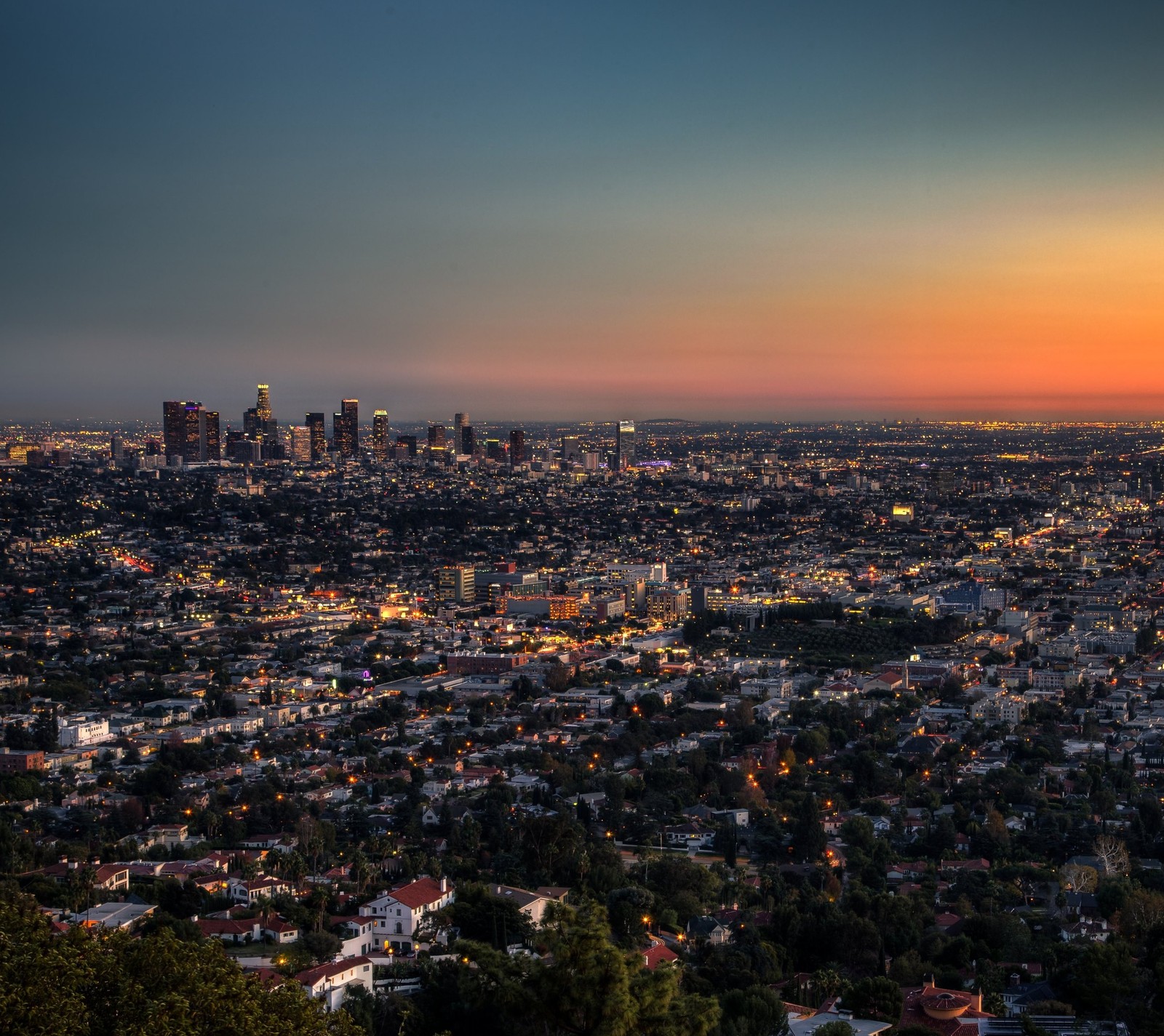 Vista arafed de uma cidade ao pôr do sol com alguns edifícios (américa, califórnia, california, los angeles, nascer do sol)