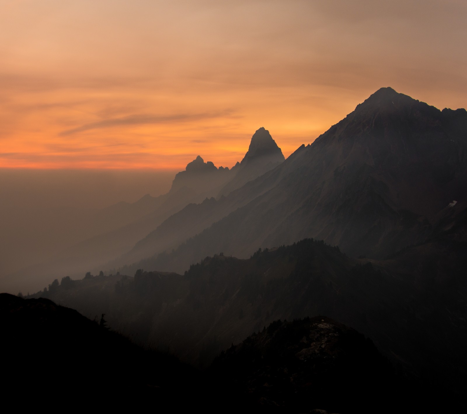 Mountains with a hazy sky and a few clouds in the distance (landscape, mountain, nature, sunset)