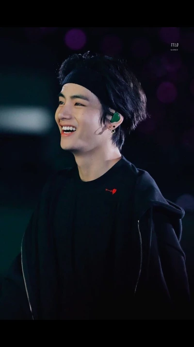 Radiante Kim Taehyung sorrindo no palco