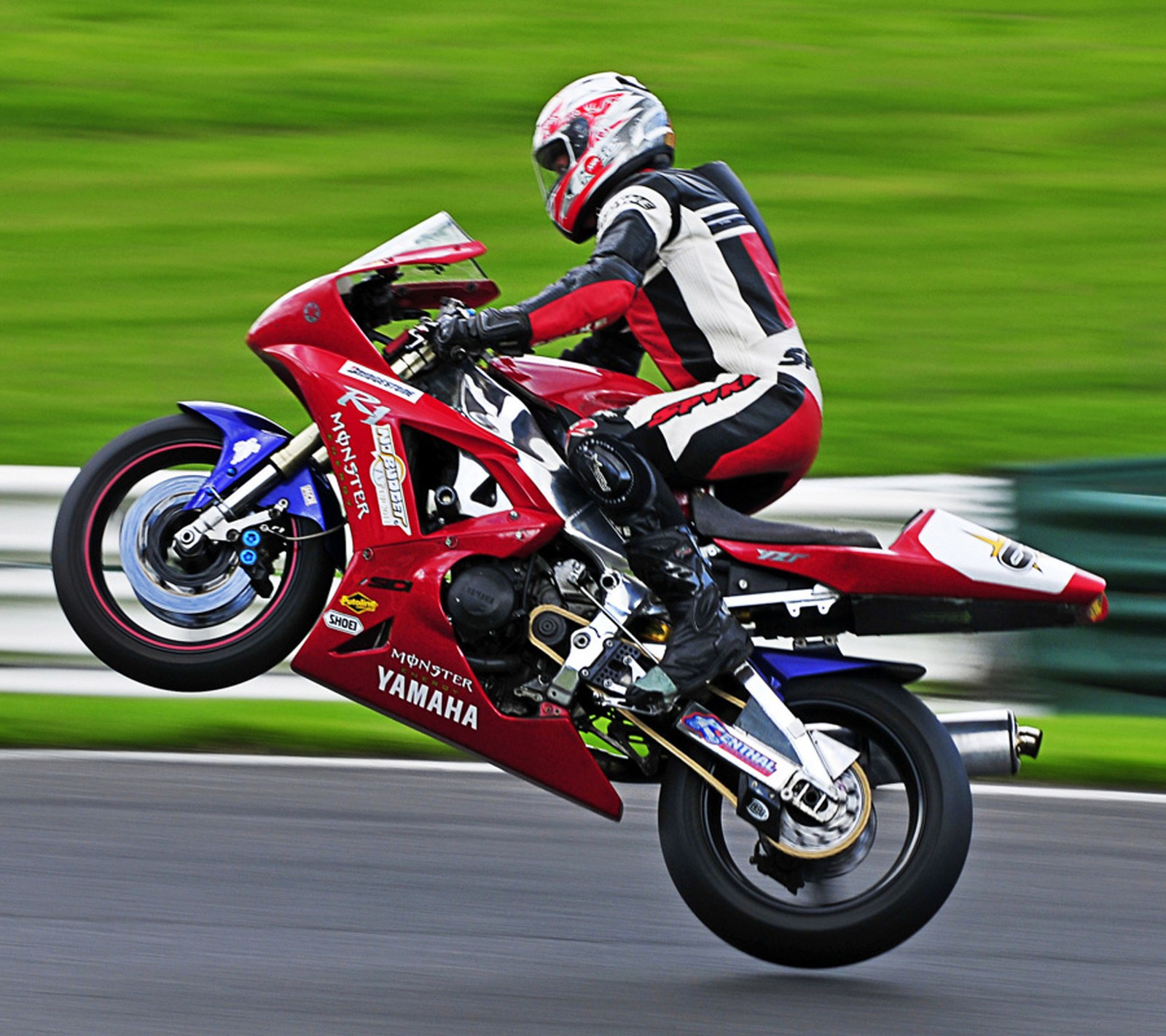 Motorradfahrer in der luft auf einem motorrad auf einer rennstrecke (macht, yamaha)