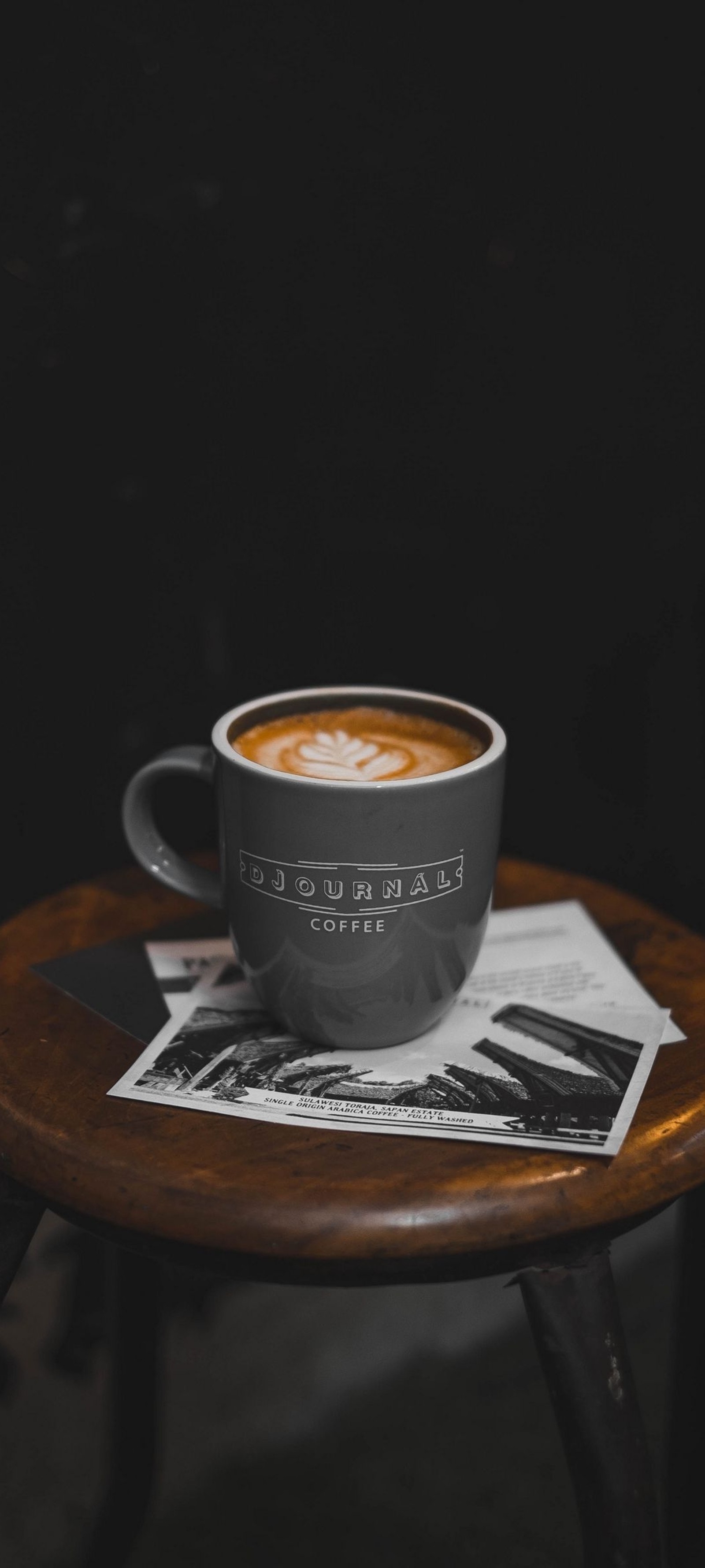 Hay una taza de café en una mesa con una revista (comida, utensilios de mesa, melange vienés, coupé, flat white)