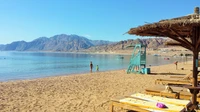 Serene Beachfront Escape with Mountains in the Background