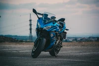 Motocicleta azul deportiva estacionada contra un fondo escénico