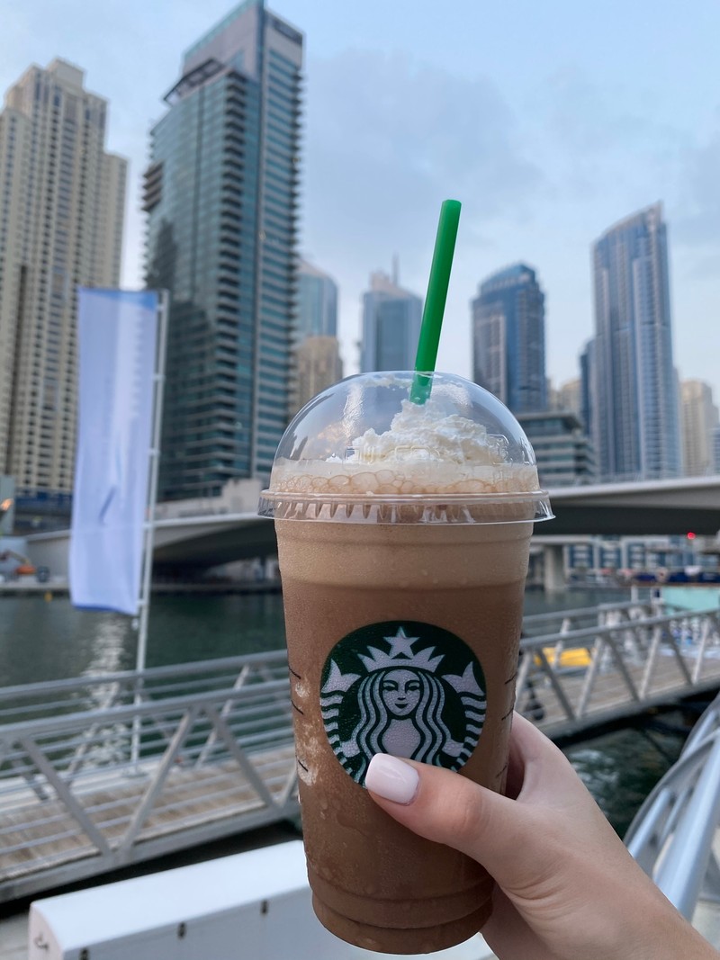 Ледяной кофе starbucks со взбитыми сливками и зеленой соломкой в чашке (дубай, dubai, молочный коктейль, кофе, башенный блок)