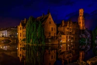 Marco histórico iluminado refletido em um canal sereno à noite