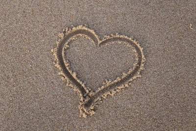 Symbole de cœur gravé dans le sable de la plage