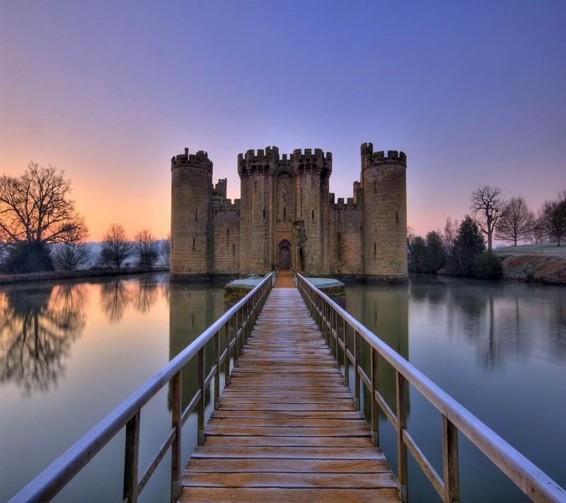 Pont arabe menant à un château avec un lac au premier plan (château, eau)