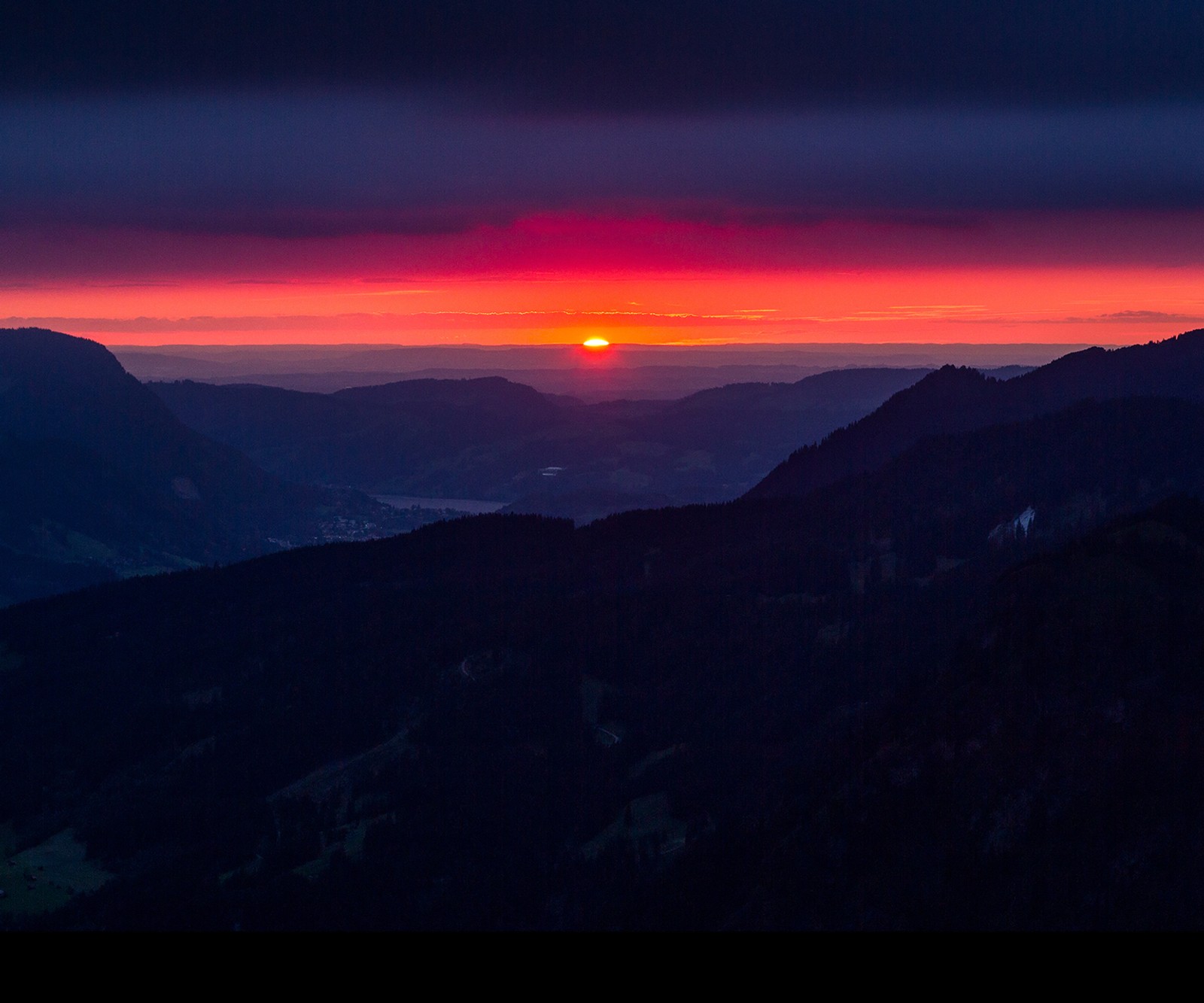 Vue d'un coucher de soleil sur une vallée avec des montagnes en arrière-plan (montagnes, coucher de soleil)