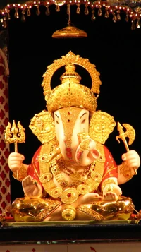 Ídolo dorado del Señor Ganesha adornado con intrincadas joyas, sentado en una pose tradicional, irradiando devoción y auspiciosidad.