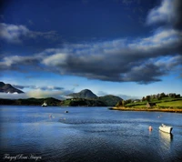 Fjord norvégien serein avec des bateaux et des montagnes majestueuses sous un ciel nuageux