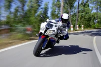 Corrida de motocicletas dinâmica em uma estrada sinuosa com um piloto em equipamento completo.