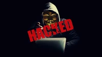 Hacker anónimo en un entorno oscuro con superposición de 'HACKED