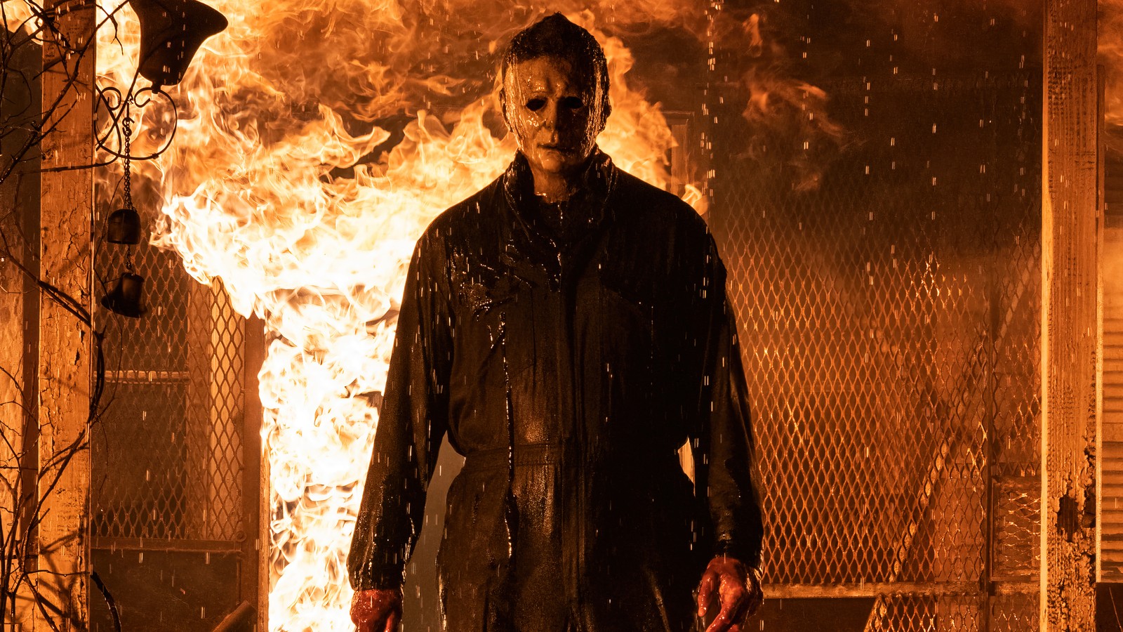 Ein mann in einer schwarzen jacke steht vor einem feuer (halloween kills, 2021, film, michael myers)