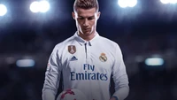 Cristiano Ronaldo com o uniforme do Real Madrid, segurando uma bola de futebol com uma expressão focada.