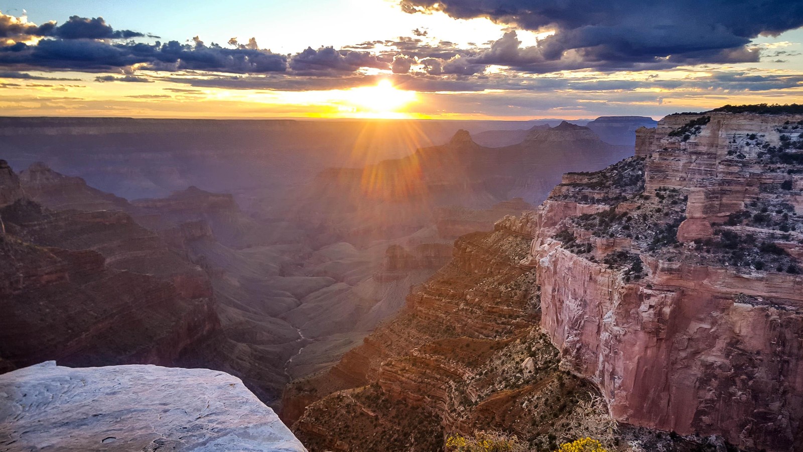 Vue d'un canyon avec un coucher de soleil en arrière-plan (parc national, canyon, badlands, roche, formation)