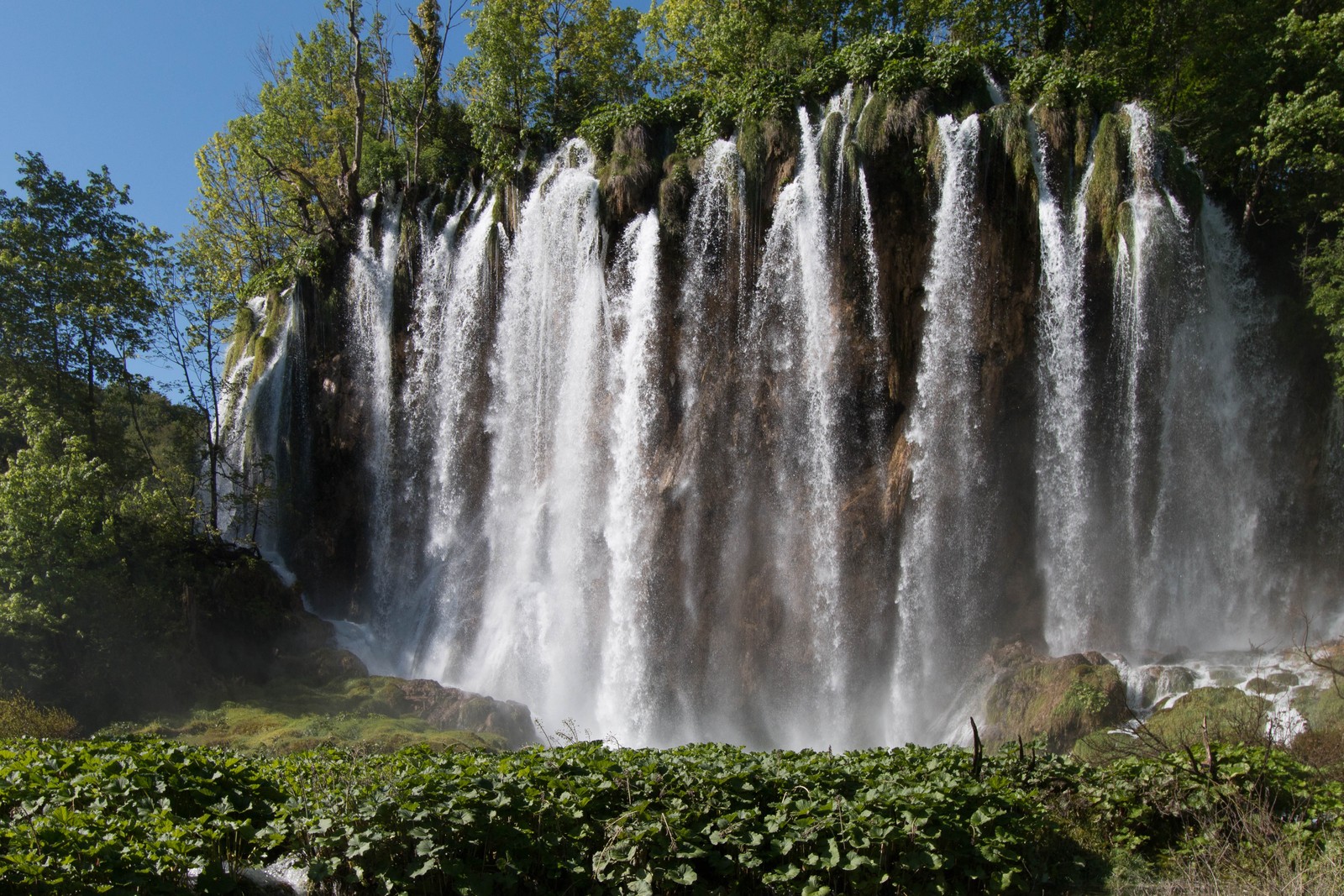 Close-up de uma cachoeira com um grande fluxo de água saindo dela (cachoeira, curso dágua, reserva natural, atração turística, natureza)