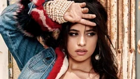 Camila Cabello in einer stylischen Jeansjacke mit auffälligem Zubehör, das ein auffälliges Mode-Statement zeigt.