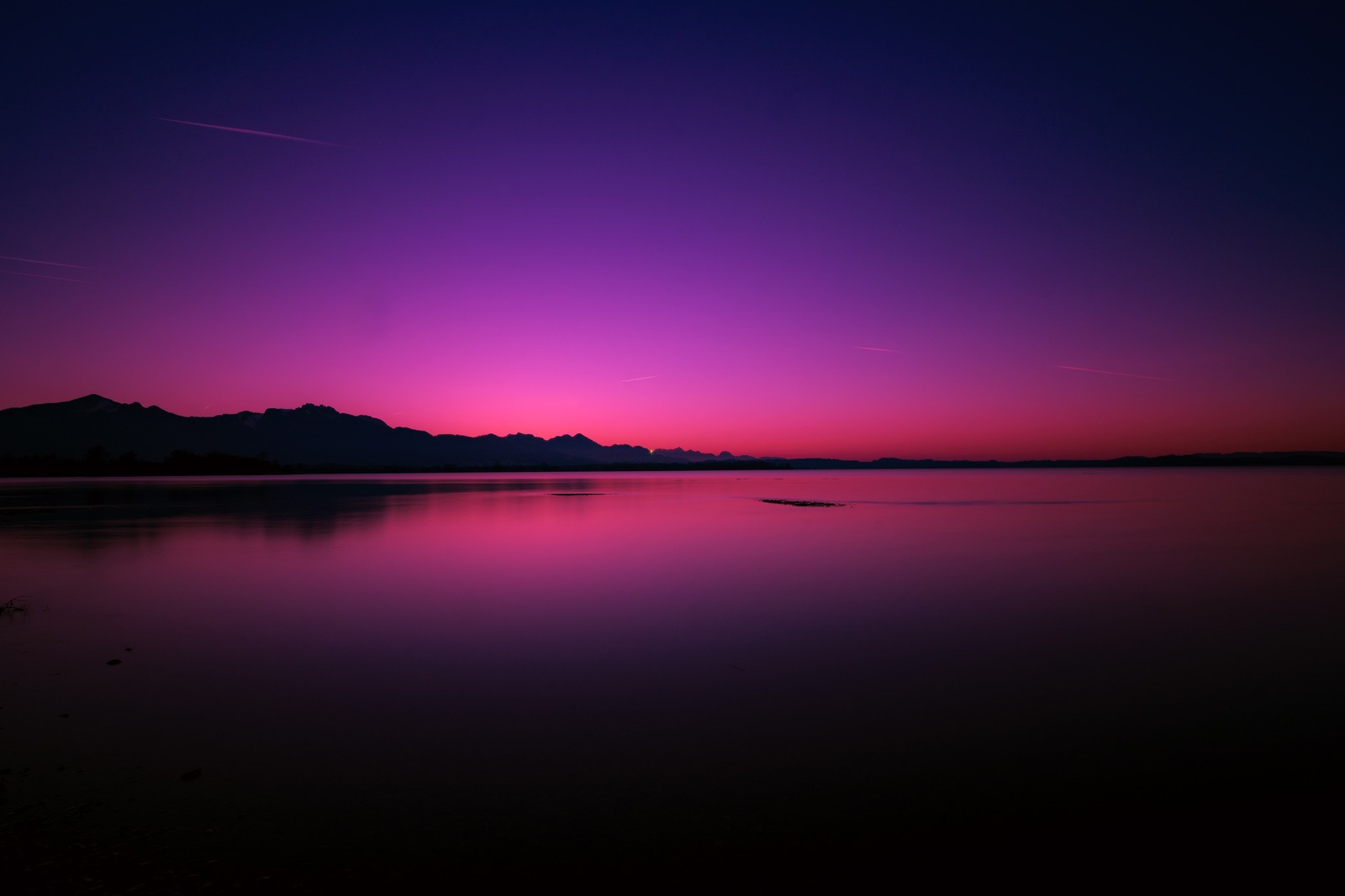 Uma vista de um pôr do sol roxo e rosa sobre um lago (por do sol, lago, crepúsculo, céu roxo, reflexo)