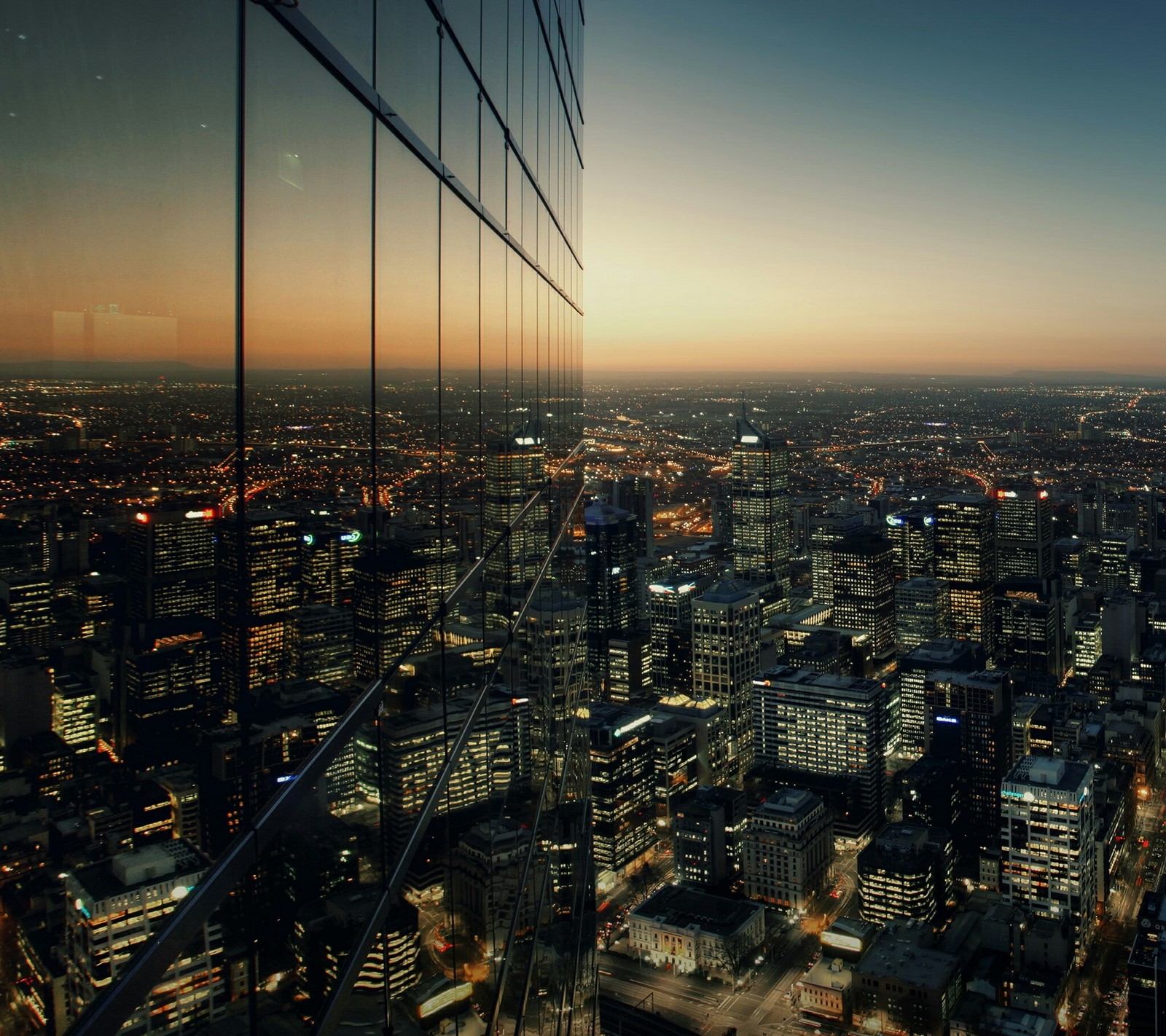 Vista de uma cidade à noite de um prédio alto (edifício, zgrada)