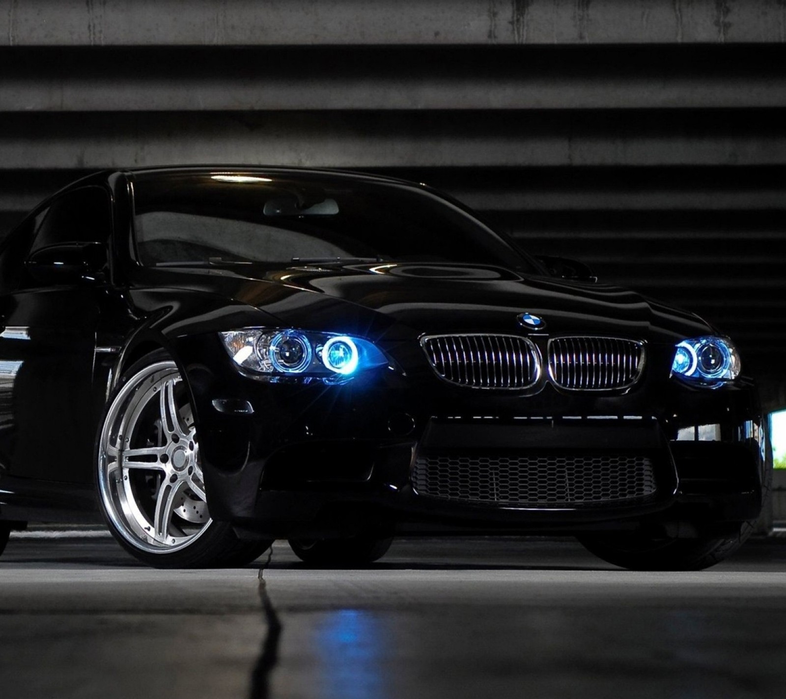 A close up of a black car parked in a parking garage (bmw, car)