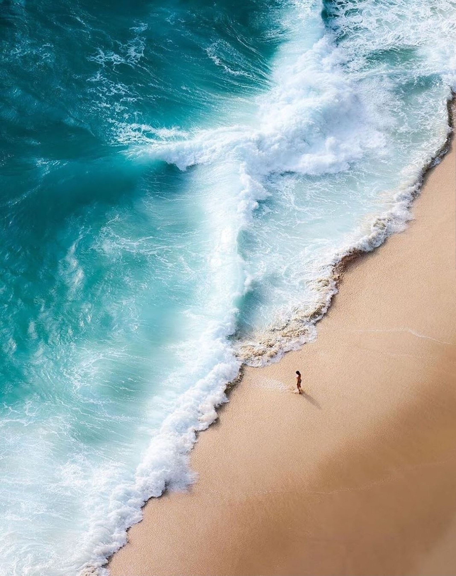 Vista aérea de uma pessoa caminhando em uma praia perto do oceano (praias, hd, mar)