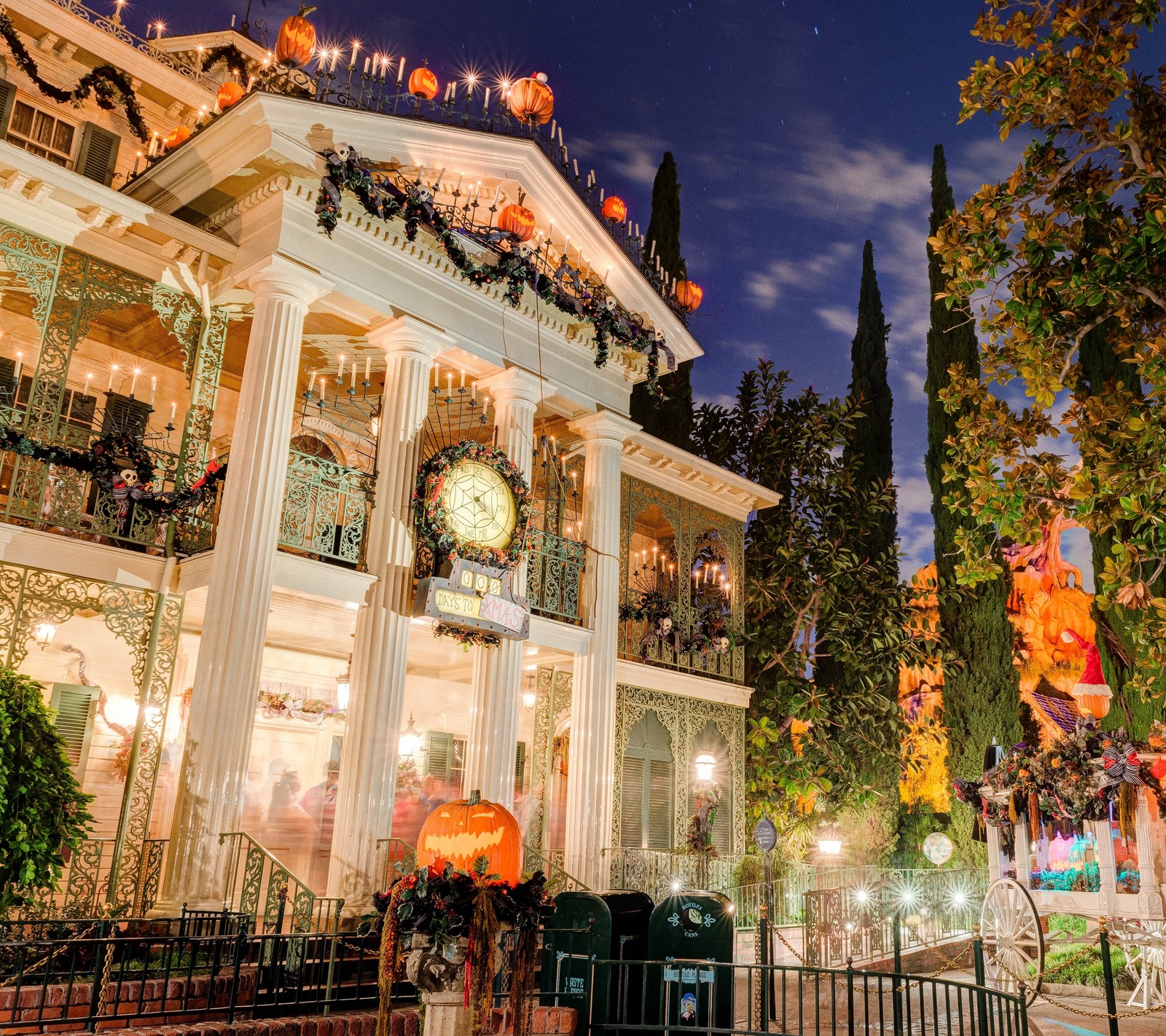 Des décorations d'halloween sur une maison dans une ville la nuit (halloween, vacances, maison, manoir, citrouille)