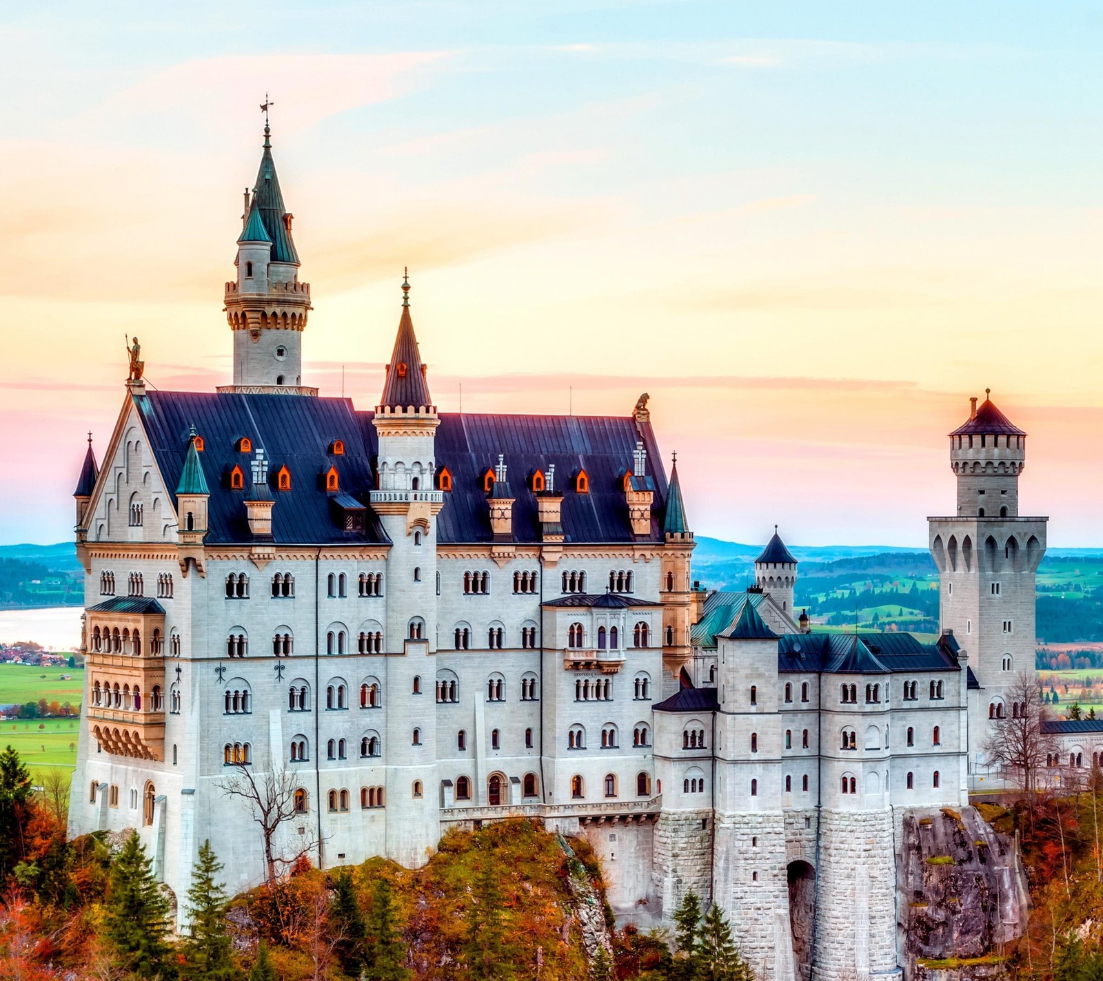 Panoramablick auf ein schloss mit einem turm und einer uhr oben (alpen, herbst, bayern, deutschland, schloss neuschwanstein)