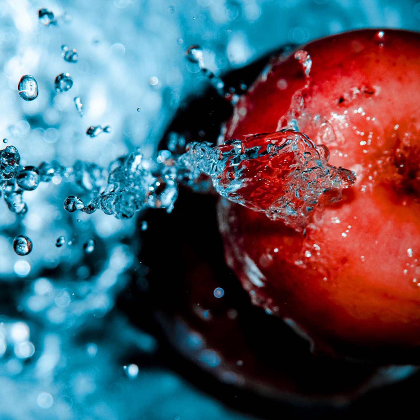 There is a red apple with water splashing on it (abstract, apple, beautiful, cool, creation)