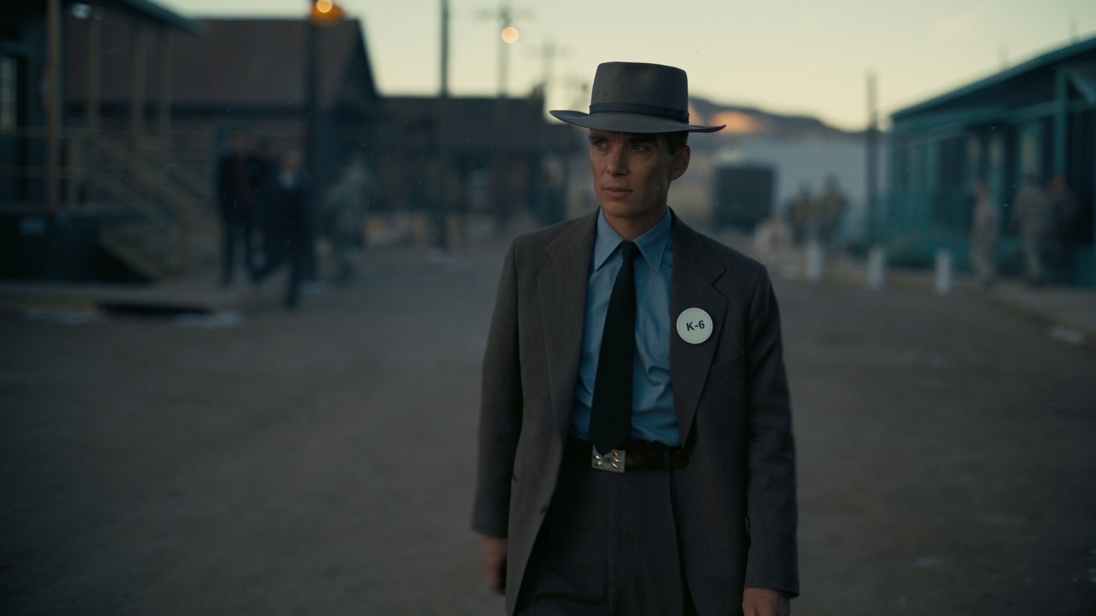 Un hombre en traje y corbata de pie en la calle (oppenheimer, película, 2023, cillian murphy)