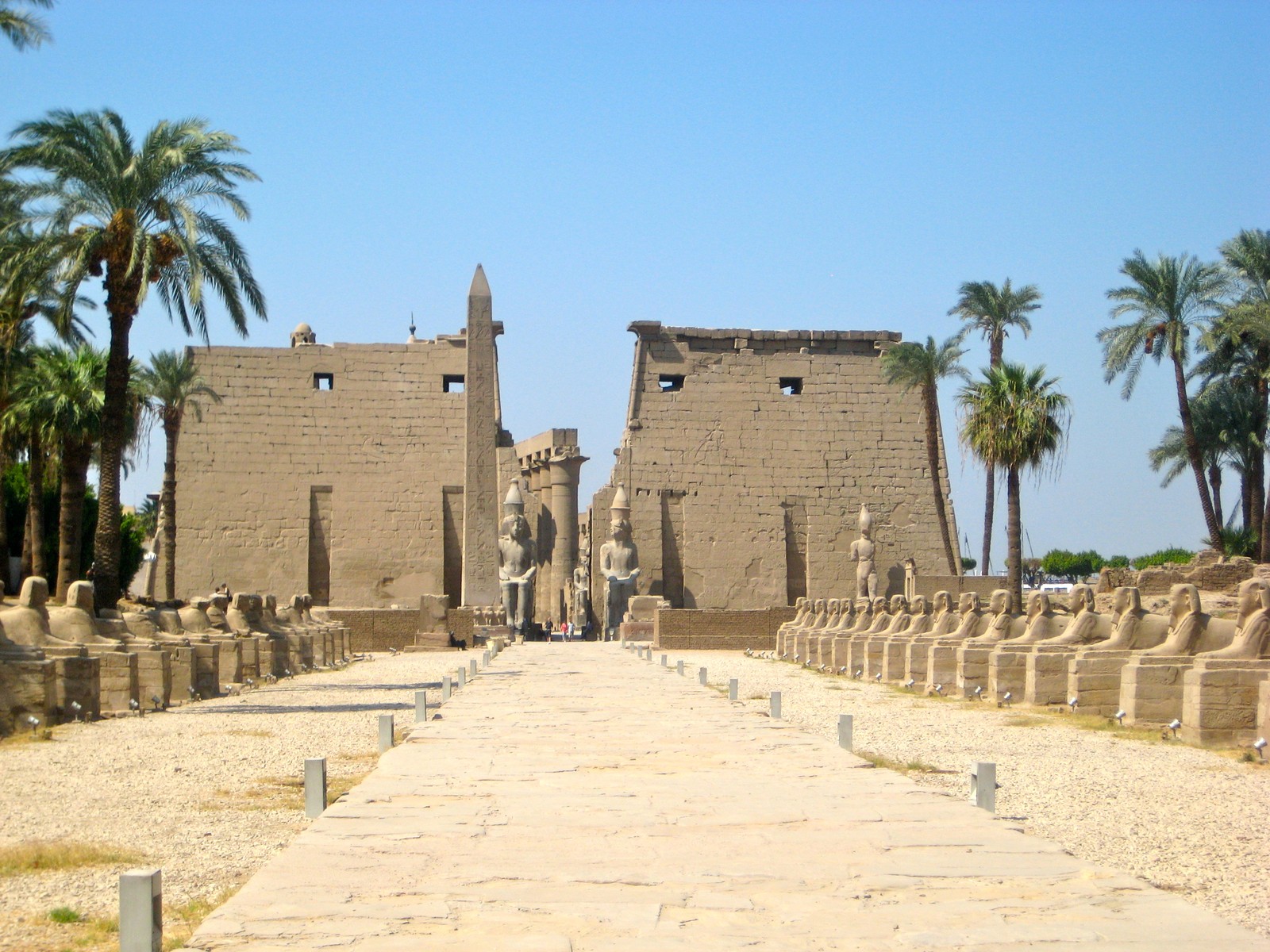 Una vista panorámica de un camino de piedra que lleva a un templo (asuán, nilo, sitio histórico, pared, sitio arqueológico)